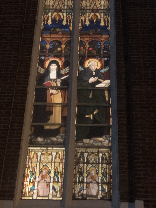 The stained glass windows at Holy Name Church on Broadway gleam after dark. Here, the Irish St. Brigid and St. Columbkille are featured in a window given by the Fr. Mathew Total Abstinence and Benevolence Society.